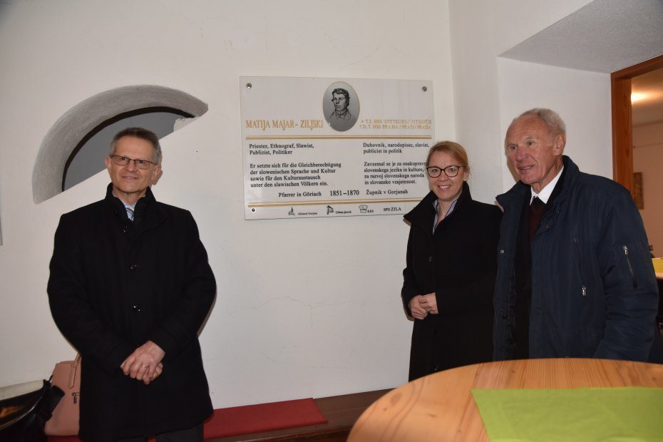 Image: Generalni konzul dr. Anton Novak, ministrica dr. Helena Jaklitsch in župnik Stanko Trap pred spominsko ploščo Matiji Majerju-Ziljskemu. Foto: Franc Wakounig 